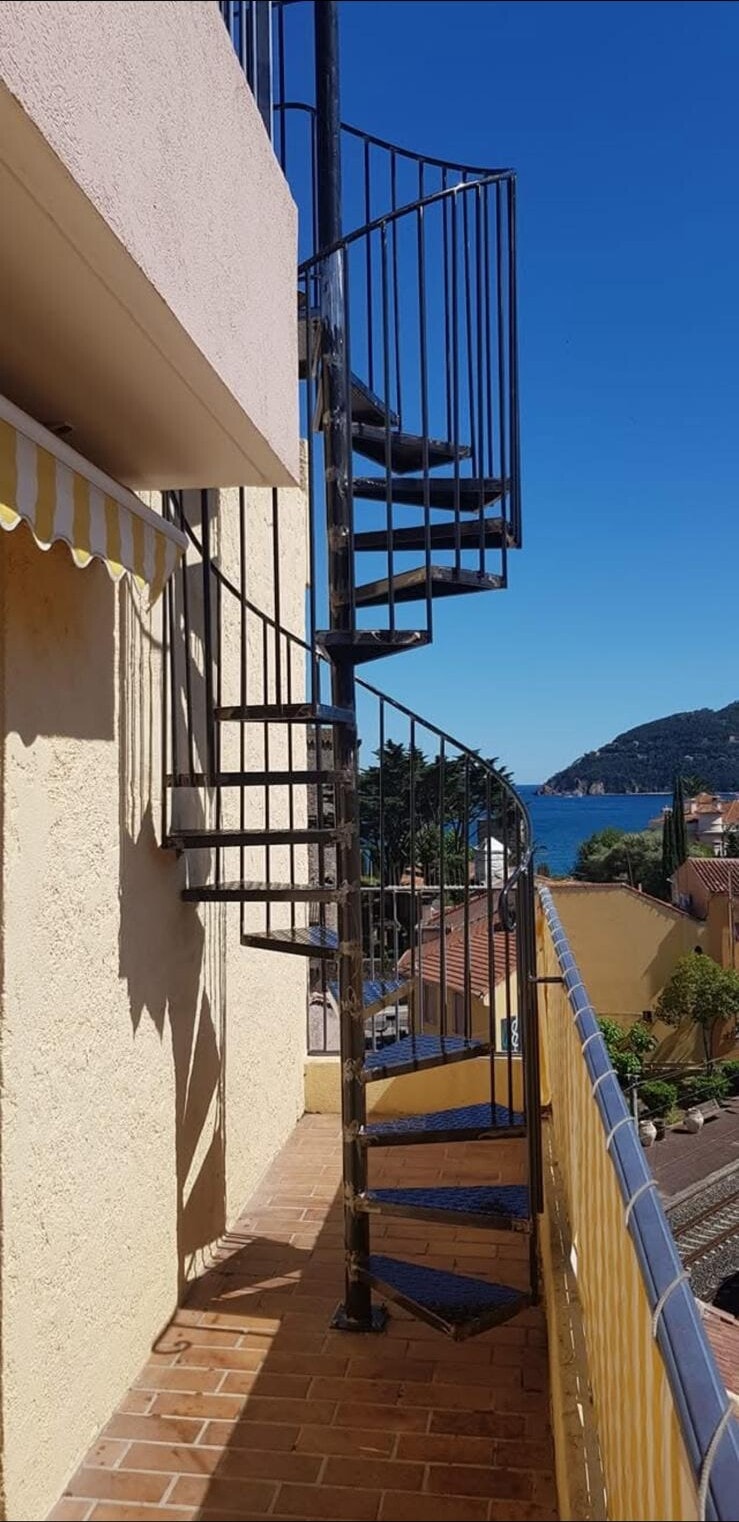 Escalier hélicoïdal en fer forgé vers un balcon, réalisé à Villefranche-sur-Mer