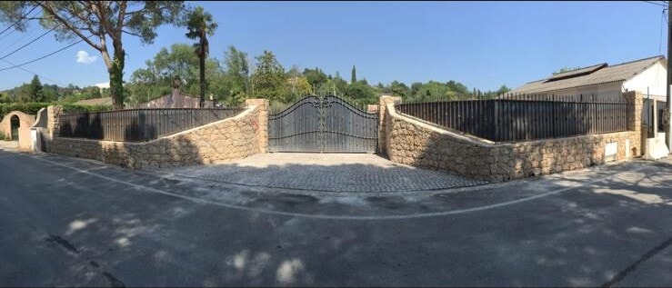 Ensemble portail et clôture en fer forgé sur mur en pierre, réalisé à Châteauneuf-Grasse
